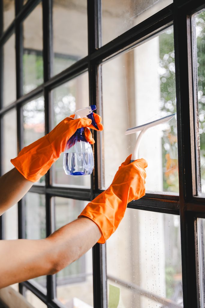 people doing cleaning are using cloths and spraying disinfectant wipe the glass in the office room. cleaning staff.cleaning maid