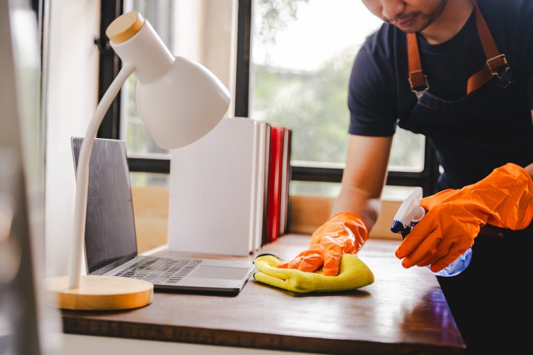 cleaning staff used cloths and sprayed disinfectant. wipe down tables and floors in the office. concept of cleaning staff with equipment