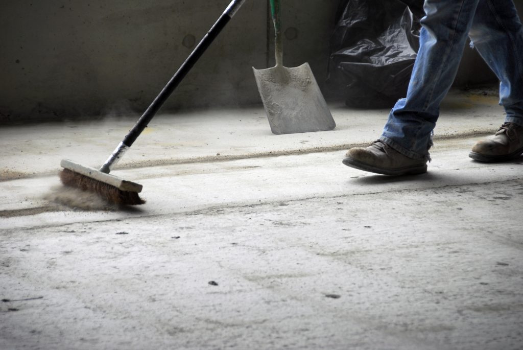 worker sweeping up at construction site